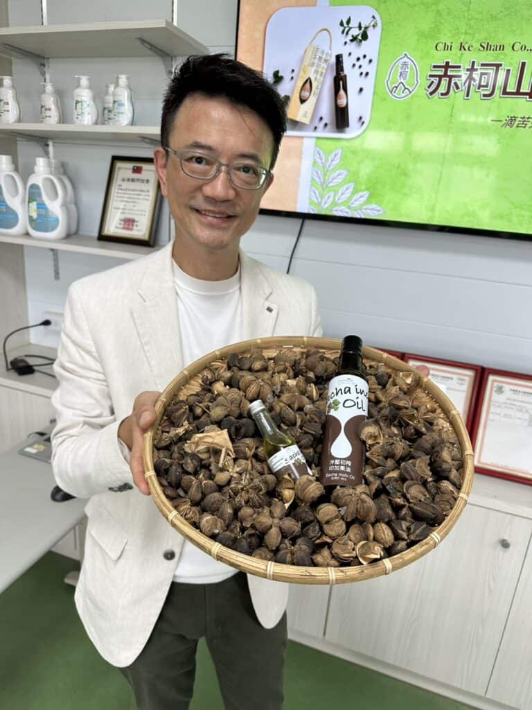 王明勇老師手拿冷壓初榨印加果油與印加果